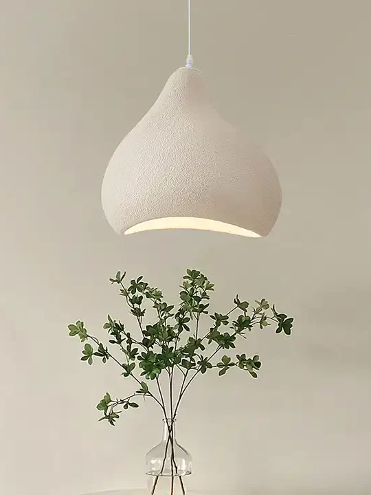 lampa otosu oświetla stolik z kwiatkiem